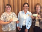 Charlotte Meade, Rotary President (center), presents check to Alice Quezada, vice president, and Wilma Humason, treasurer (far right), friends of the Kings County Library.